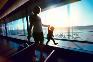 Young woman and her son trying to amuse themselves while waiting on an airport lounge